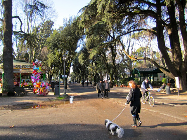 padrona passeggia con cane a villa borghese roma nella natura e con dei palloncini nello sfondo