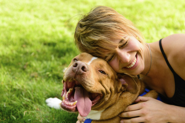 premios para perros -propietaria sonriendo junto a su perro pitbull