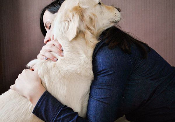 female dog owner hugging golden retriever lost dog DogBuddy article