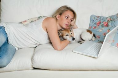 Profesional canino versus Internet - Chica con su perro usando un portatil