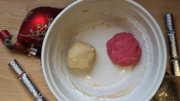 Two dough balls in a bowl for a candy cane christmas dog treat recipe